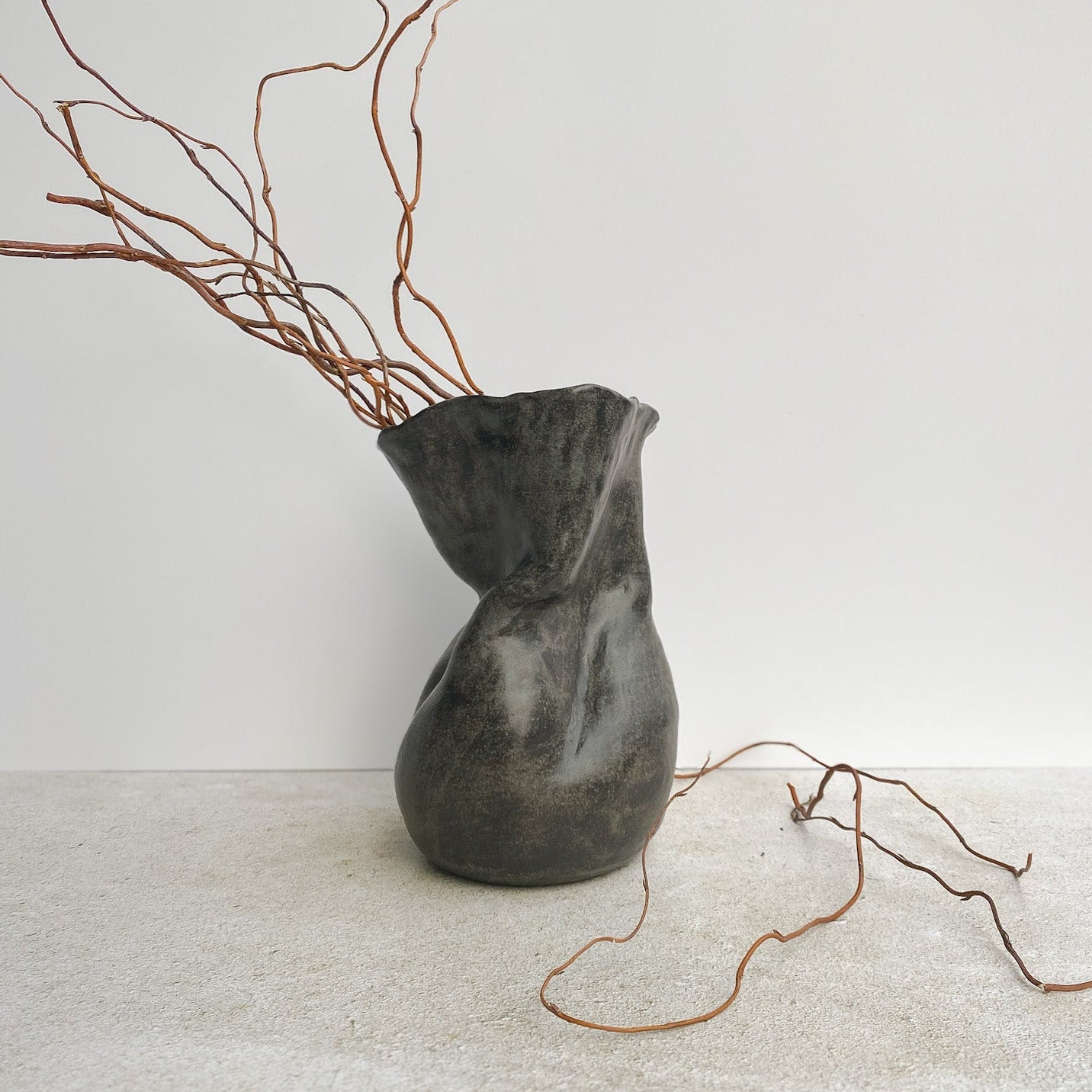 Ceramic vase with branches on a white surface