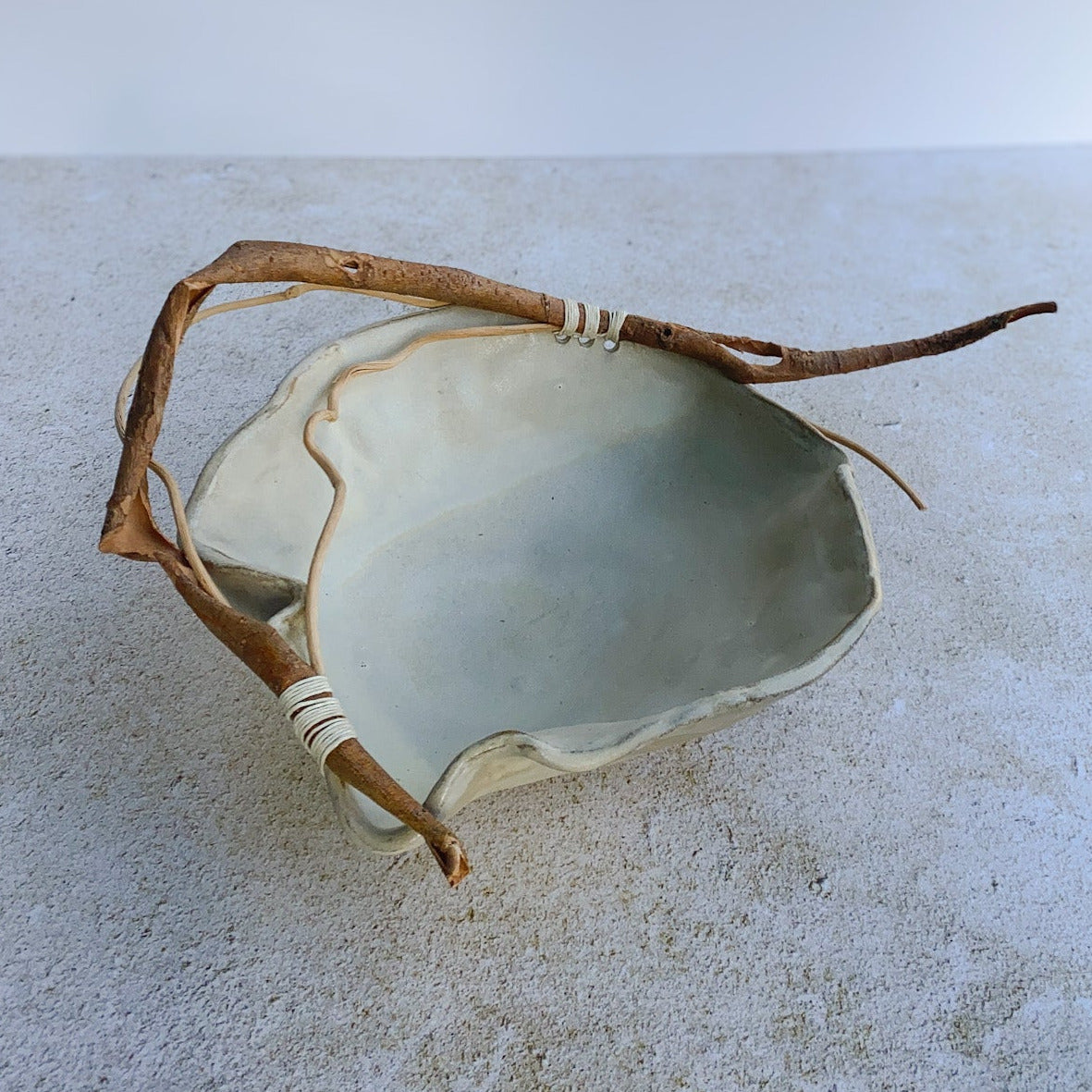 Ceramic bowl with a branch on a textured surface