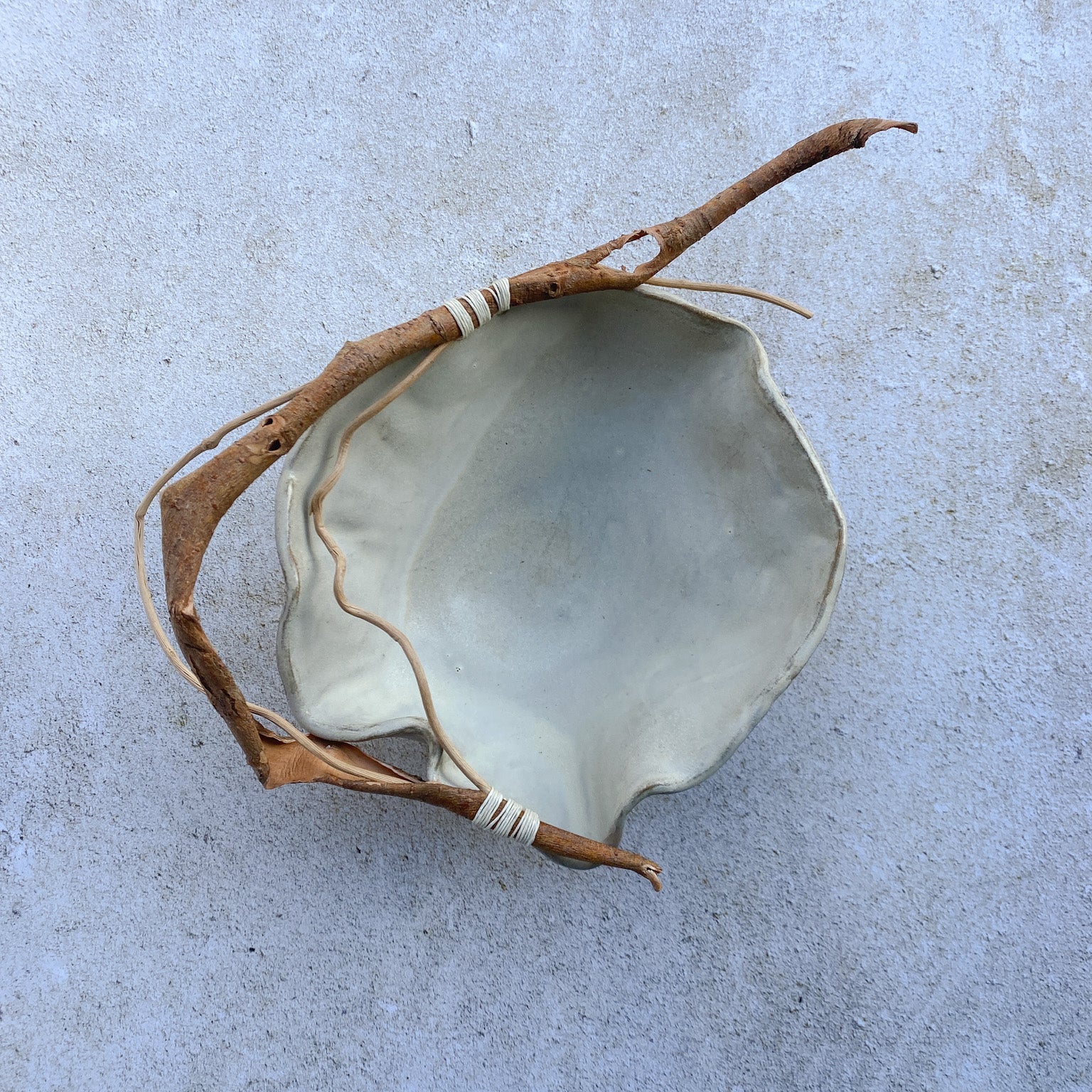 Ceramic bowl with a natural branch on a gray surface