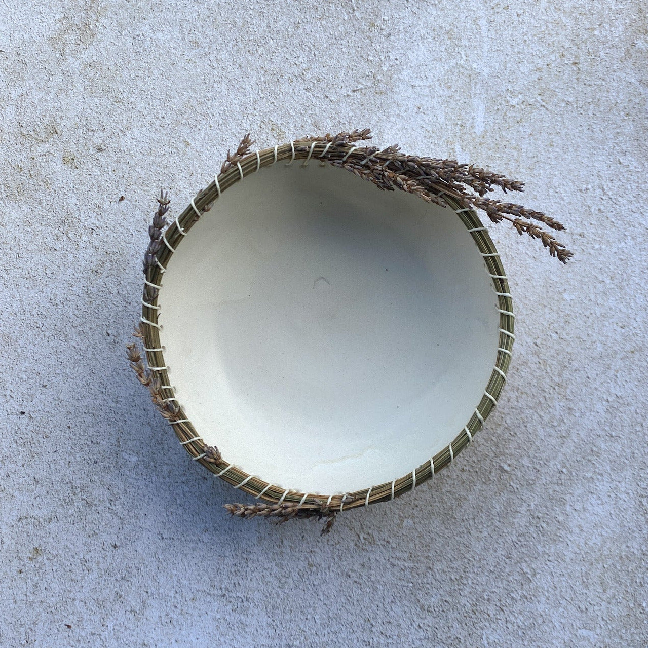 Dried lavender rim on a white ceramic bowl on a light gray surface