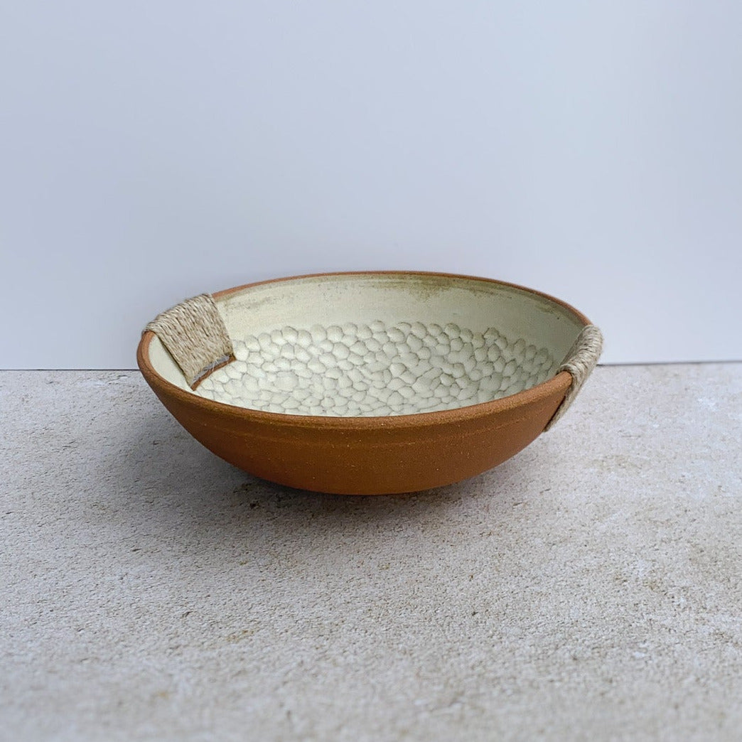 Ceramic bowl with textured surface on a light gray background