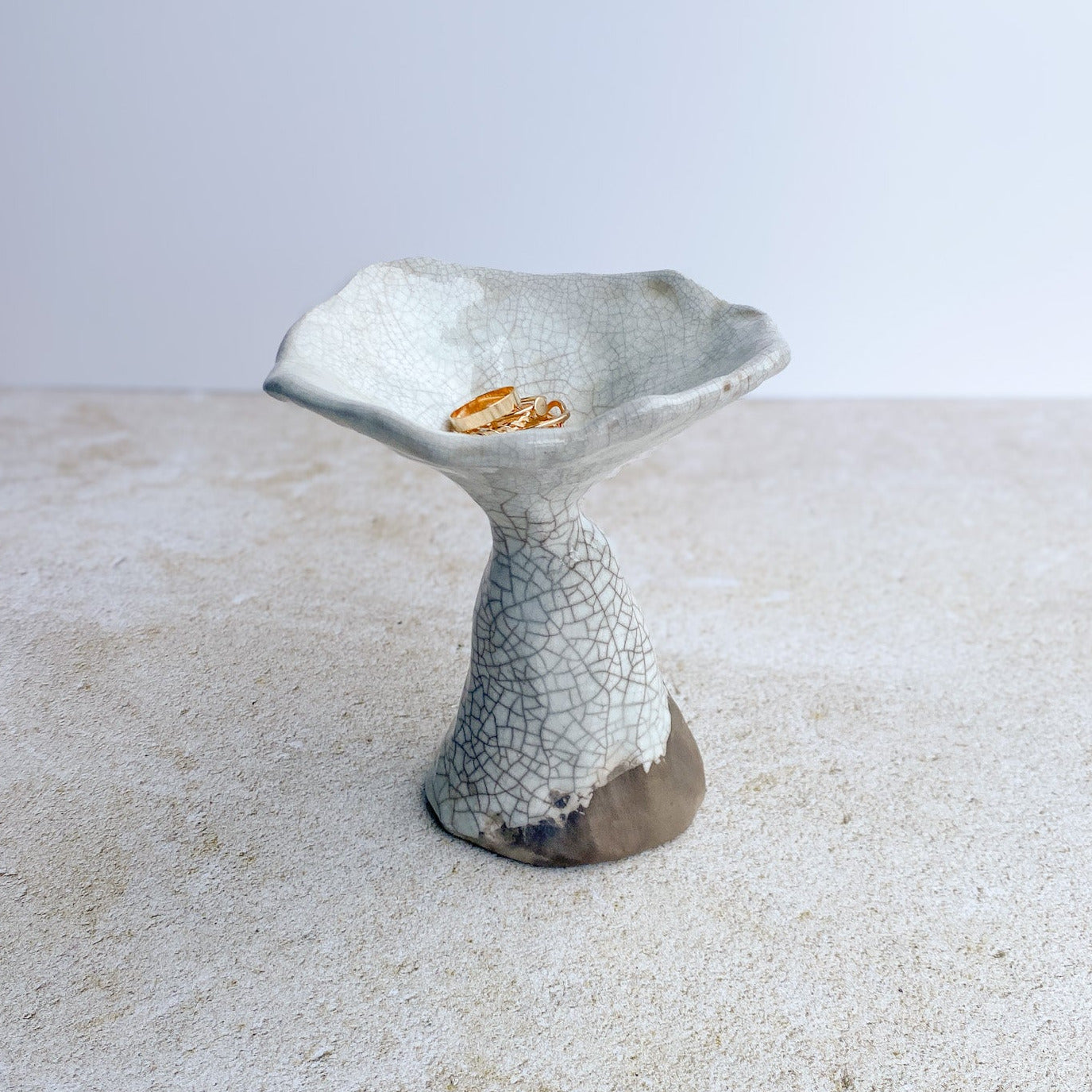 Ceramic mushroom ring dish with textured surface on a light background