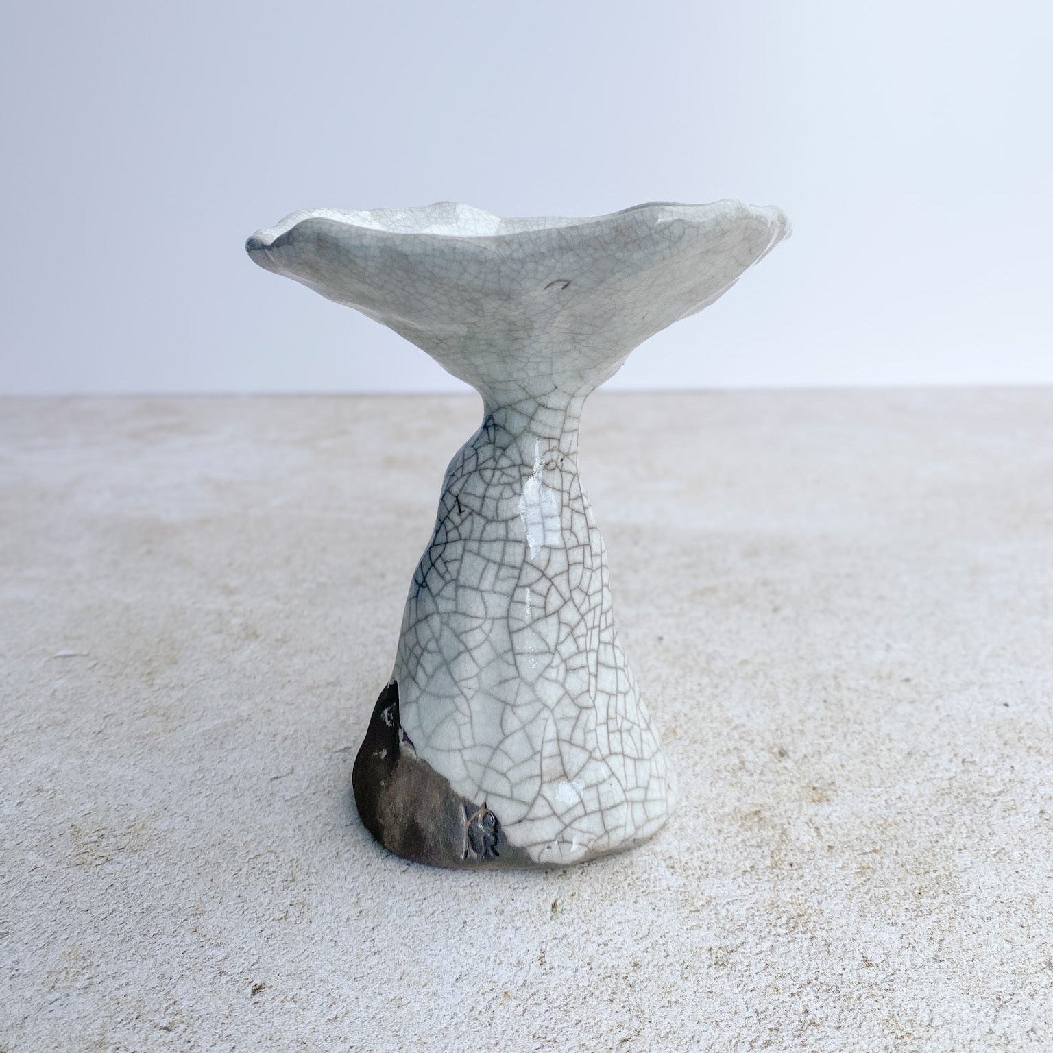 Ceramic sculpture with a textured surface on a light background