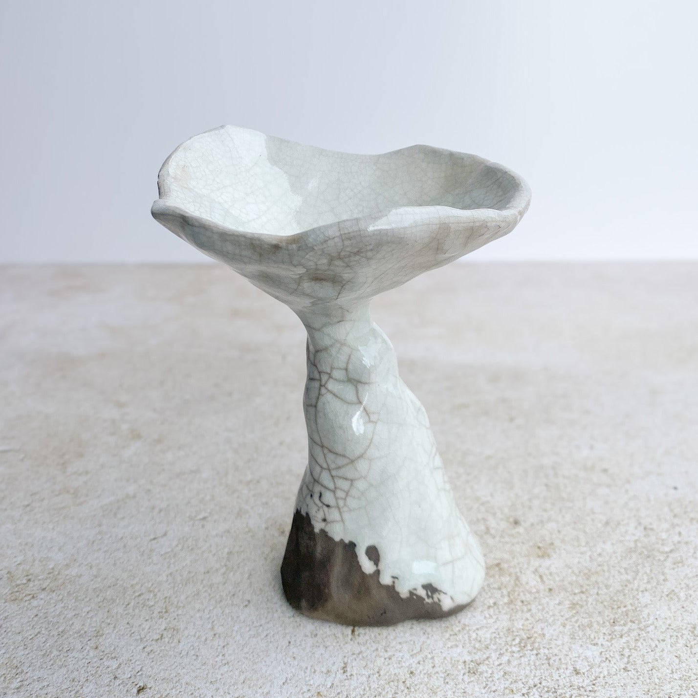 Ceramic mushroom scultpure with textured surface on a light background