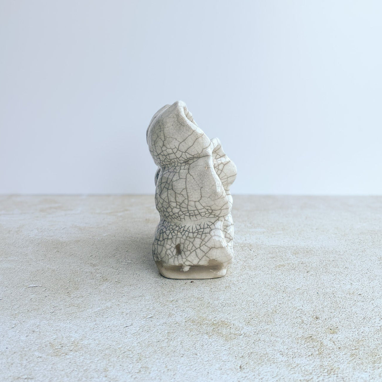 Ceramic sculpture with a raku white crackle glaze on a white and grey background