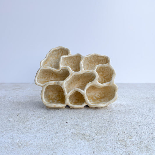Ceramic sculpture with a unique, organic design on a light background