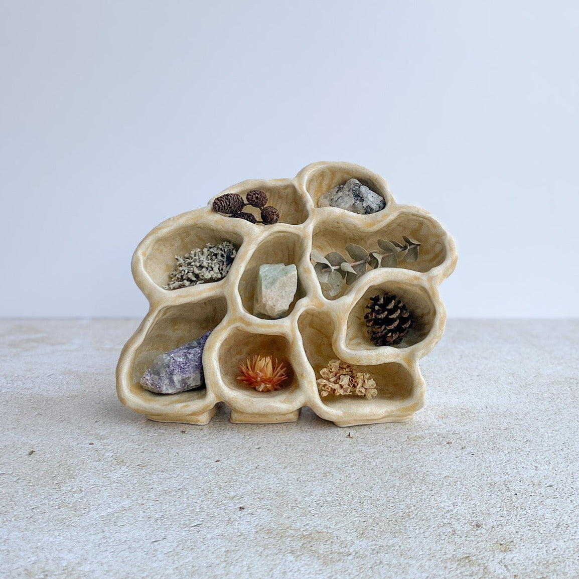 Ceramic holder with small stones on a white surface