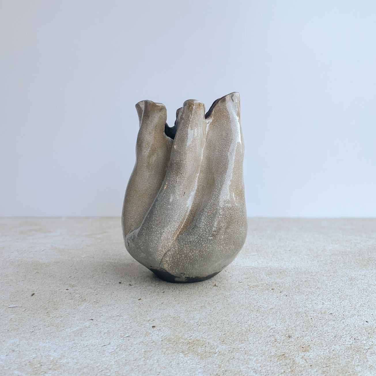 Ceramic raku sculpture vase on a textured surface