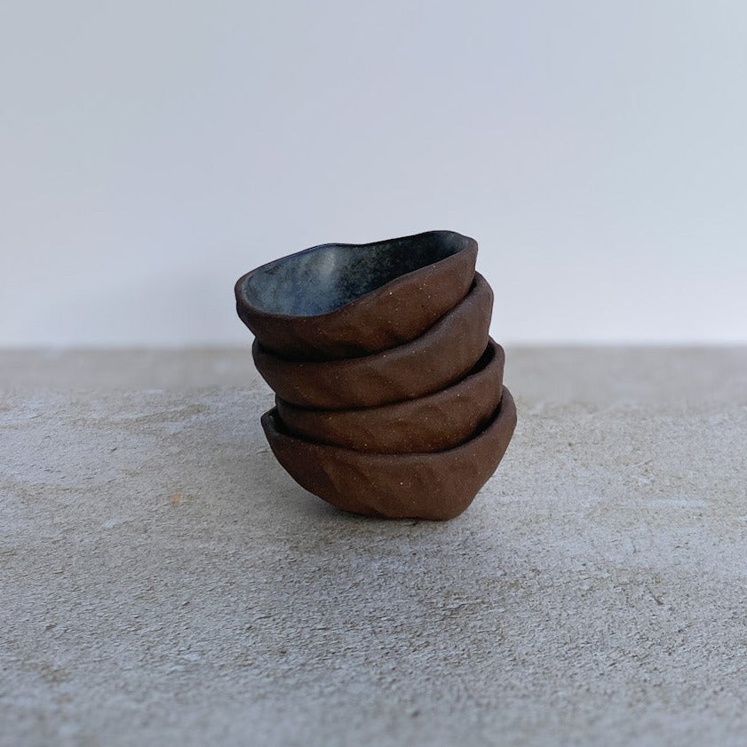 Stack of ceramic bowls on a textured surface with a white background