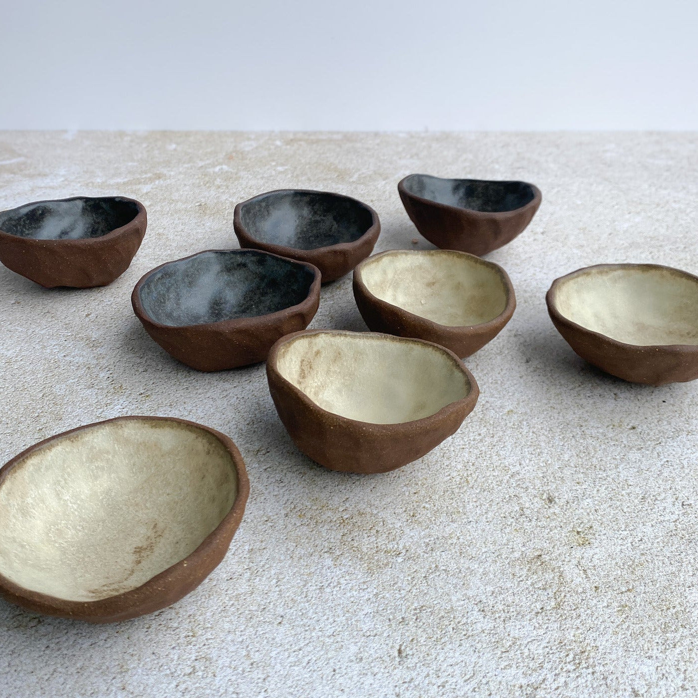 Set of ceramic bowls on a textured surface with a neutral background