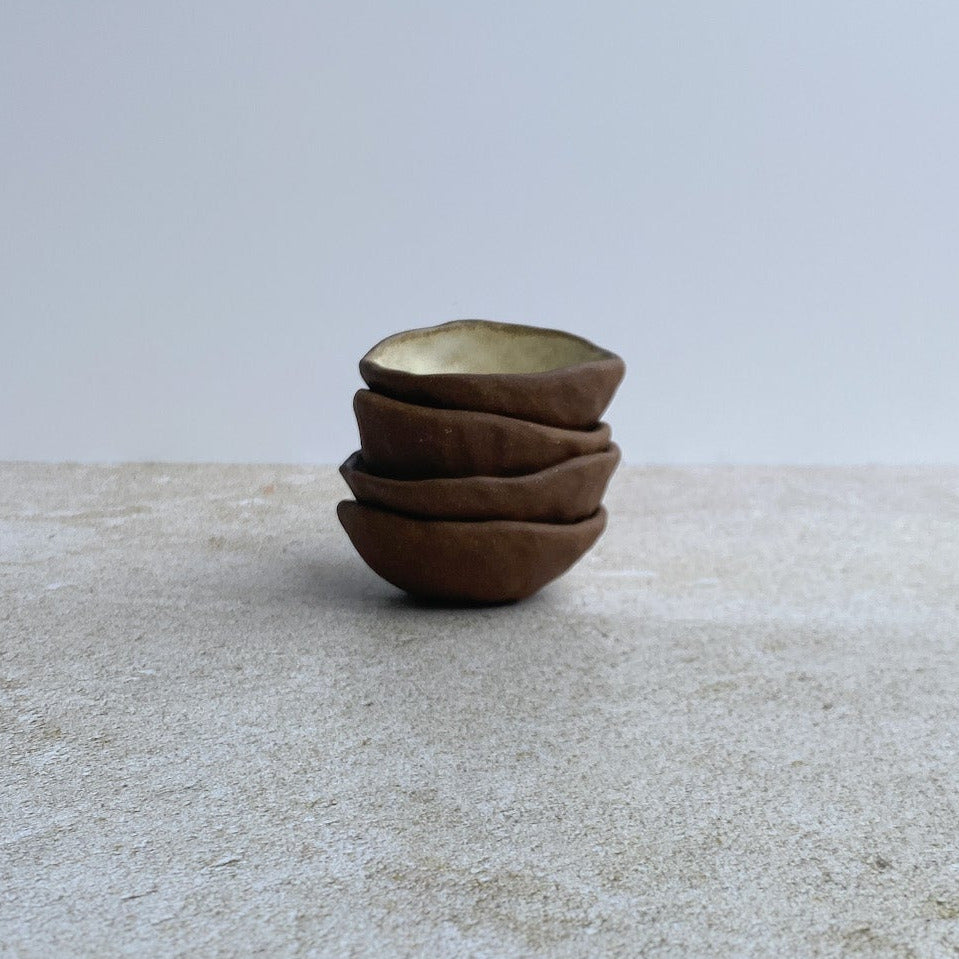 Stack of small ceramic bowls on a textured surface with a light gray background
