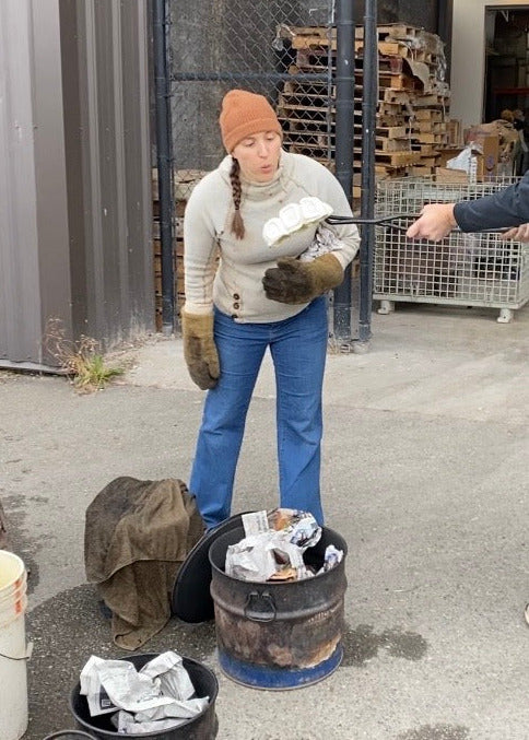 Two people in a warehouse making raku pottery.